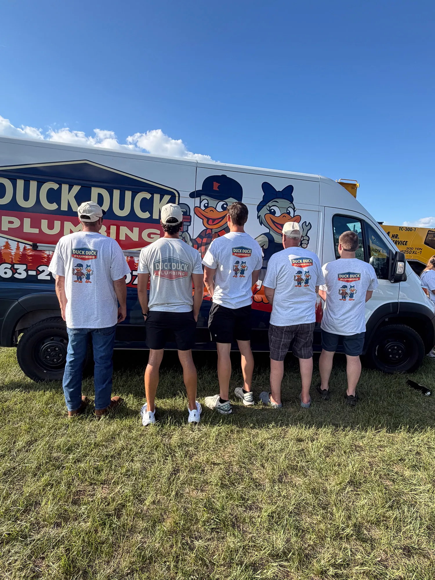 Duck Duck Plumbing shirts in front of the service van